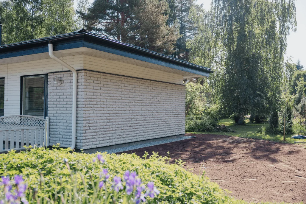 Valkoinen omakotitalo ja piha